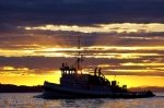 A stunning sunset over the serene waters off Northern Vancouver Island in British Columbia as a commercial fishing boat heads home for the day.